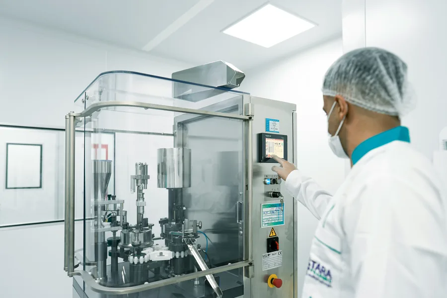 Technician operating scientific manufacturing equipment
